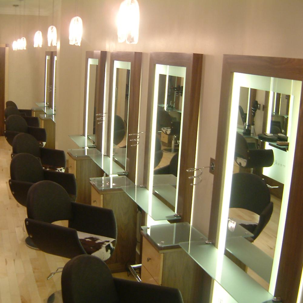 Woodfords styling stations with black chairs and framed mirrors