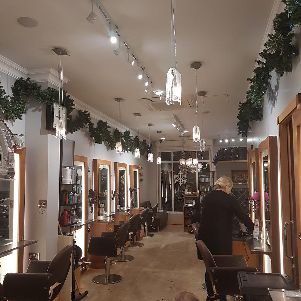 Inside Woodfords salon, with styling chairs, mirrors and pendant lighting